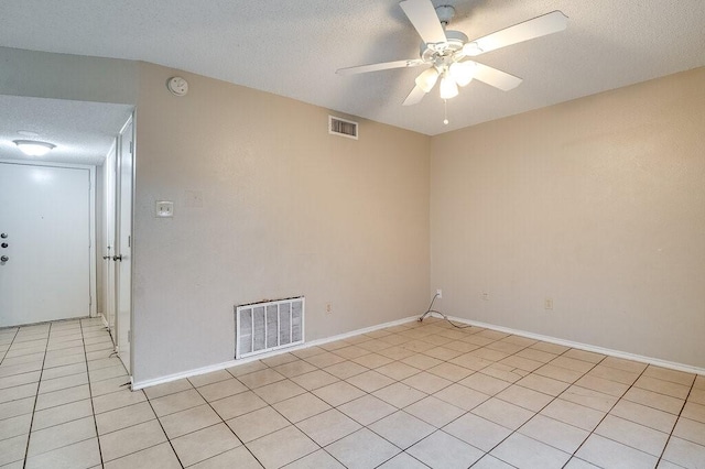 tiled spare room with ceiling fan and a textured ceiling