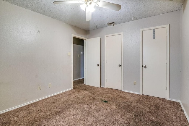 unfurnished bedroom with a textured ceiling, carpet floors, and ceiling fan