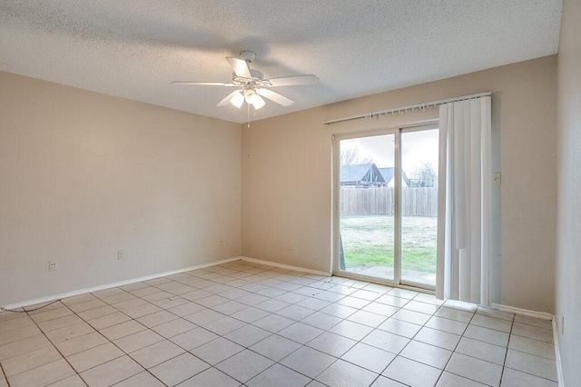 spare room featuring ceiling fan, light tile patterned flooring, and a textured ceiling