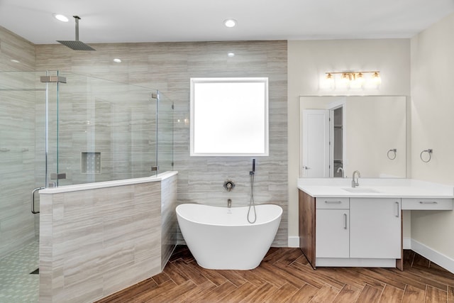 full bath featuring recessed lighting, a freestanding tub, a shower stall, and vanity