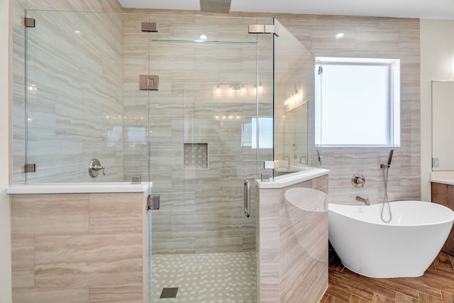 bathroom with a stall shower and a freestanding tub