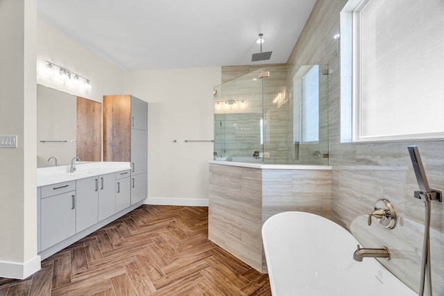 bathroom with vanity, visible vents, a freestanding bath, baseboards, and a shower stall