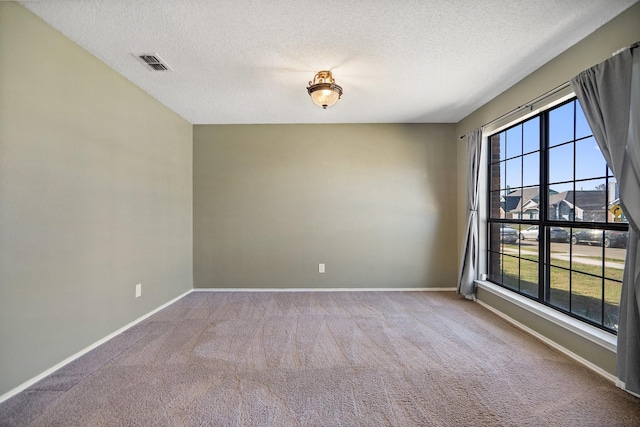 carpeted spare room featuring a textured ceiling