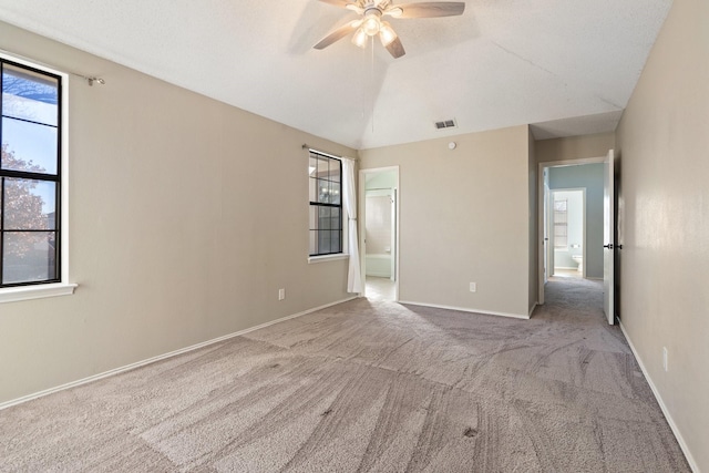 unfurnished room featuring light colored carpet, vaulted ceiling, and ceiling fan