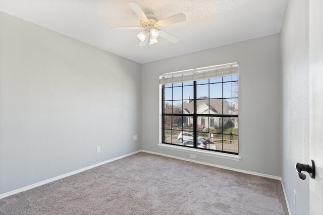 carpeted spare room with plenty of natural light, ceiling fan, and a textured ceiling