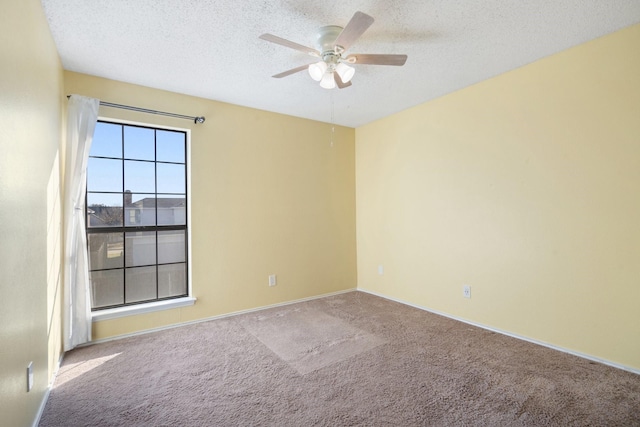 carpeted empty room featuring ceiling fan and a textured ceiling