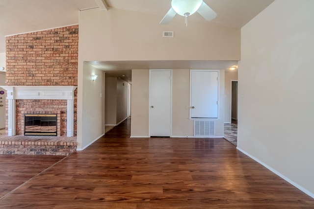 unfurnished living room featuring beamed ceiling, a fireplace, dark hardwood / wood-style floors, and ceiling fan