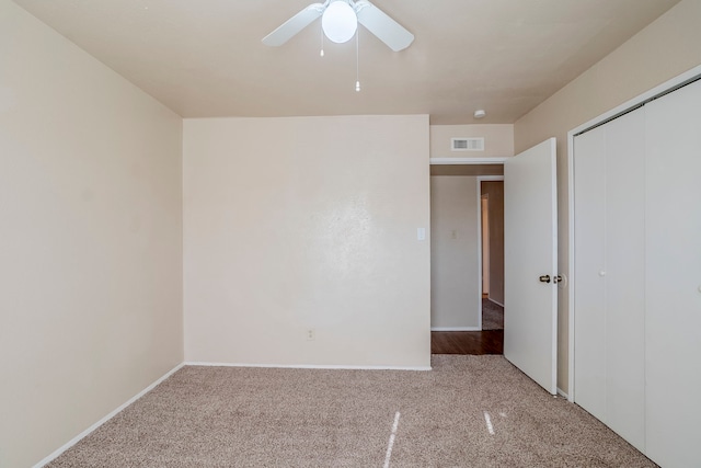 unfurnished bedroom with ceiling fan, light carpet, and a closet