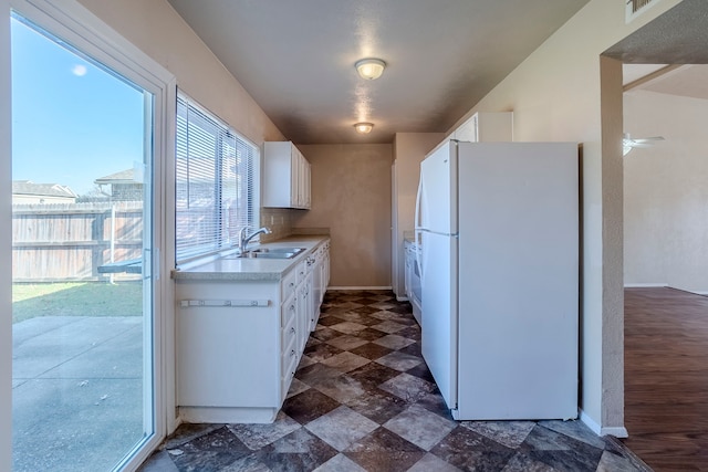 kitchen featuring white cabinets, white refrigerator, and sink