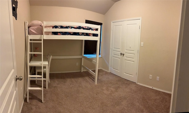 unfurnished bedroom featuring carpet and vaulted ceiling