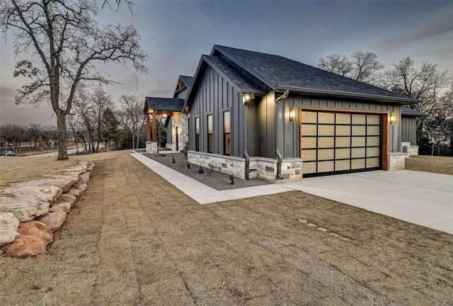 property exterior at dusk featuring a garage and a lawn