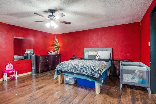 bedroom with a textured ceiling, dark hardwood / wood-style floors, and ceiling fan