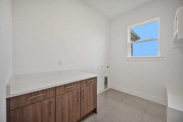 571 N Armstrong Rd, Venus, TX 76084 - laundry area with gas dryer hookup, electric dryer hookup, cabinet space, baseboards, and light tile patterned flooring
