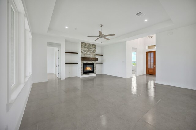571 N Armstrong Rd, Venus, TX 76084 - unfurnished living room with ceiling fan, visible vents, tile patterned flooring, a fireplace, and a raised ceiling