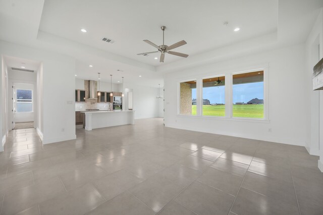 571 N Armstrong Rd, Venus, TX 76084 - unfurnished living room featuring visible vents, ceiling fan, light tile patterned flooring, and a tray ceiling