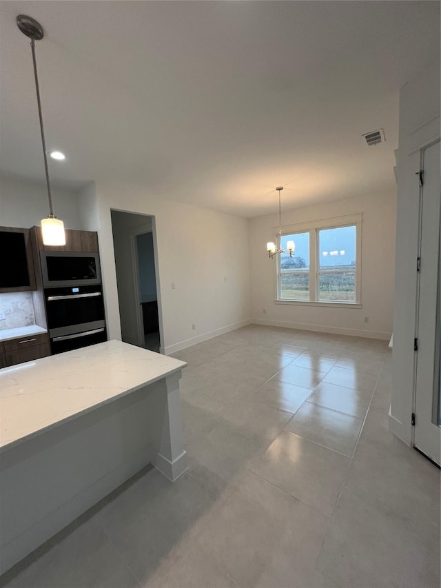 kitchen featuring stainless steel microwave, hanging light fixtures, and a chandelier