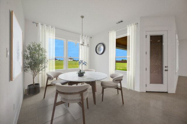571 N Armstrong Rd, Venus, TX 76084 - tiled dining room with visible vents, baseboards, a wealth of natural light, and an inviting chandelier