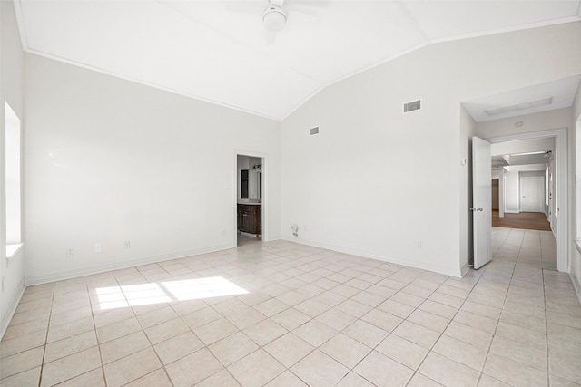 tiled empty room featuring vaulted ceiling and ceiling fan