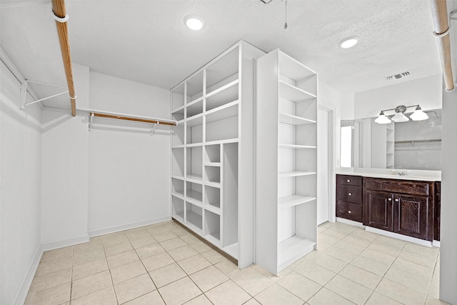 walk in closet with sink and light tile patterned floors