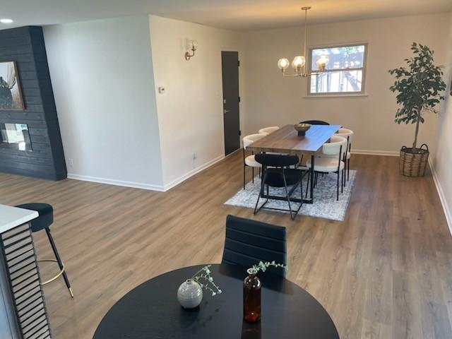 dining space with hardwood / wood-style floors and a notable chandelier