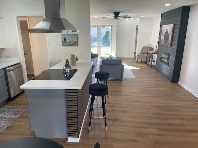 kitchen with a kitchen breakfast bar, stainless steel dishwasher, gray cabinets, black electric cooktop, and extractor fan