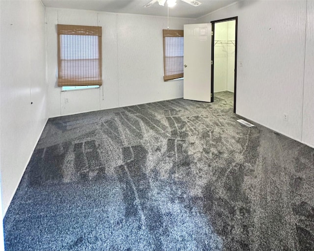 carpeted spare room featuring ceiling fan