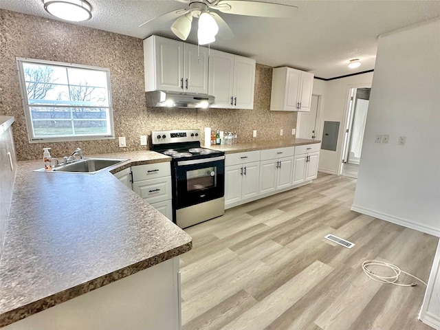 kitchen with stainless steel electric stove, white cabinets, sink, ceiling fan, and a textured ceiling