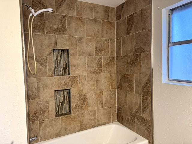 bathroom featuring tiled shower / bath