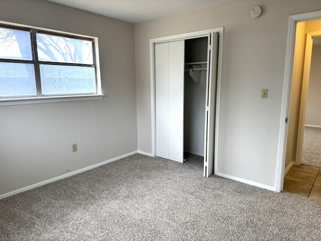 unfurnished bedroom featuring carpet flooring and a closet