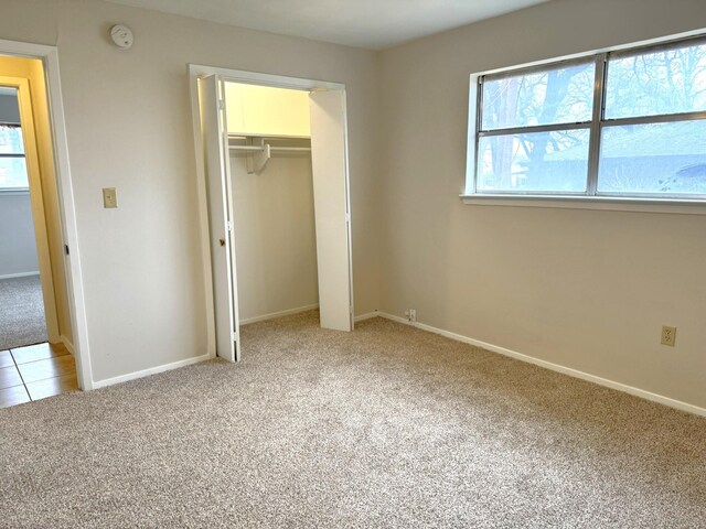 unfurnished bedroom featuring carpet and a closet