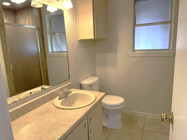 bathroom with tile patterned floors, vanity, toilet, and a shower with shower door