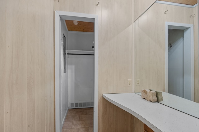 bathroom featuring wooden walls and tile patterned flooring