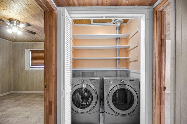 laundry area with ceiling fan, wood walls, wood ceiling, and washing machine and clothes dryer