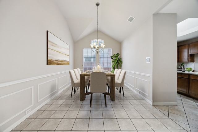 tiled dining room featuring lofted ceiling and a notable chandelier