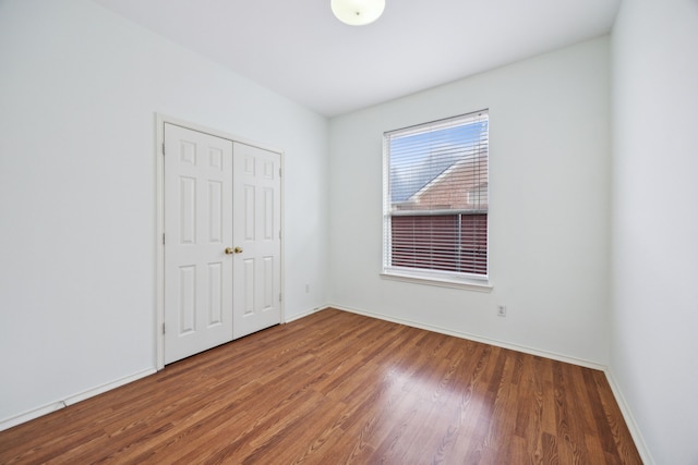 unfurnished bedroom featuring a closet and dark hardwood / wood-style floors