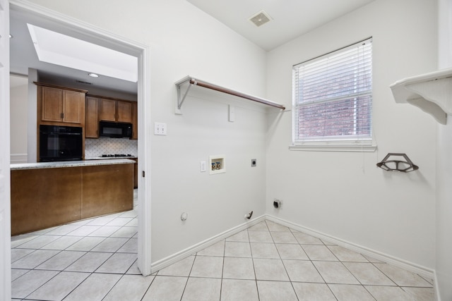 washroom with washer hookup, light tile patterned floors, hookup for a gas dryer, and electric dryer hookup