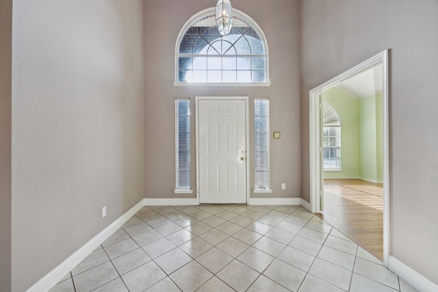 entrance foyer featuring light tile patterned flooring and a towering ceiling