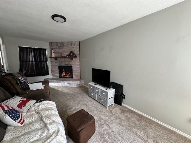 living room with light carpet, a brick fireplace, and a textured ceiling