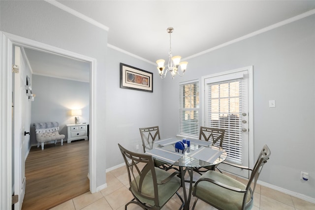 tiled dining room featuring a notable chandelier and ornamental molding