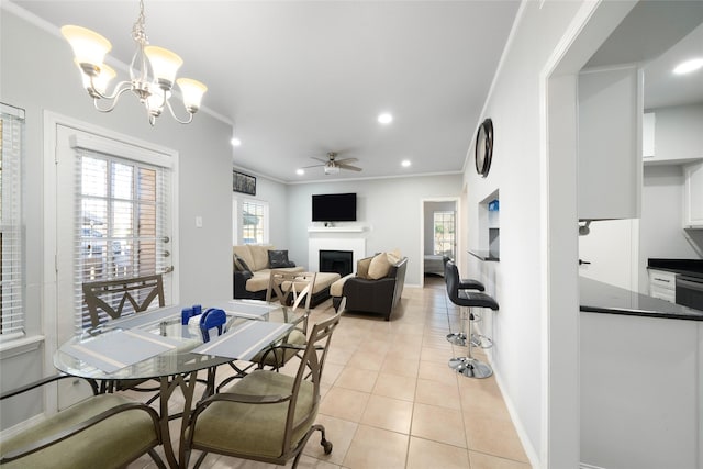 dining space featuring ceiling fan with notable chandelier, light tile patterned flooring, and ornamental molding