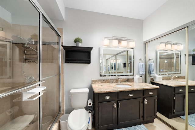 bathroom with tile patterned flooring, vanity, toilet, and walk in shower