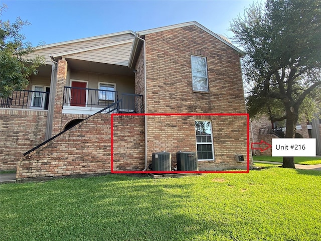 view of side of home with a yard and central AC unit