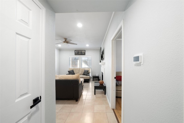 hall with light tile patterned floors and crown molding