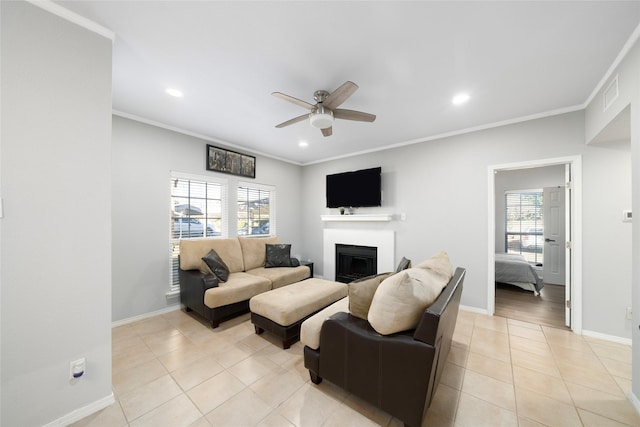 tiled living room with ceiling fan, plenty of natural light, and ornamental molding