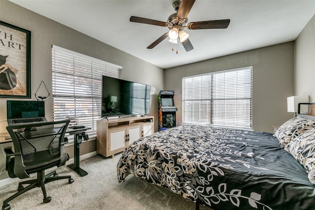 bedroom featuring multiple windows, ceiling fan, and light carpet