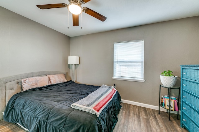 bedroom with ceiling fan and dark hardwood / wood-style flooring