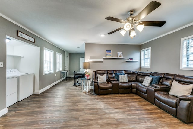 living room featuring hardwood / wood-style flooring, ceiling fan, washing machine and dryer, and ornamental molding