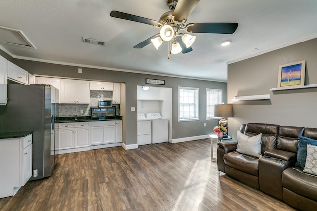 living room with washing machine and clothes dryer, ceiling fan, dark hardwood / wood-style flooring, and ornamental molding