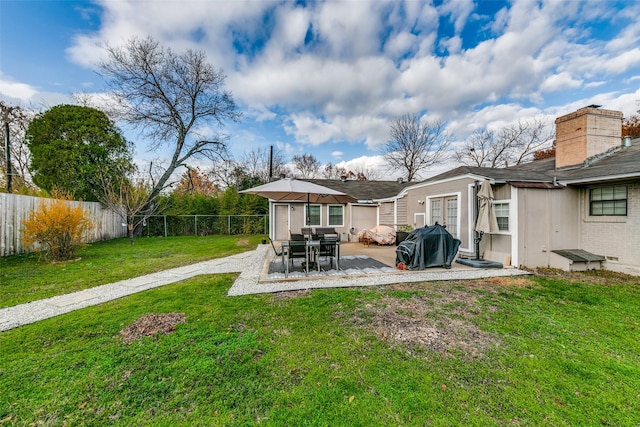 rear view of house with a patio area and a yard