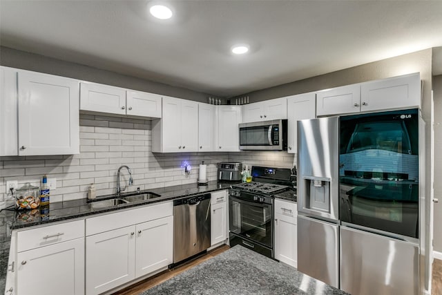 kitchen featuring white cabinets, dark stone countertops, sink, and appliances with stainless steel finishes